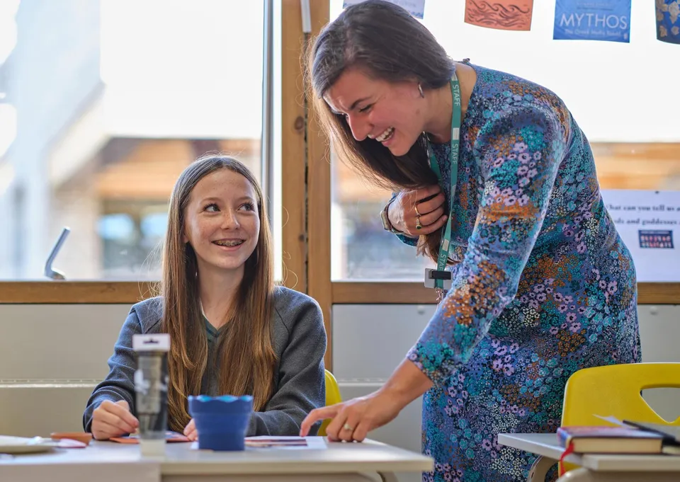 Maestra integradora conversando con una estudiante en el aula